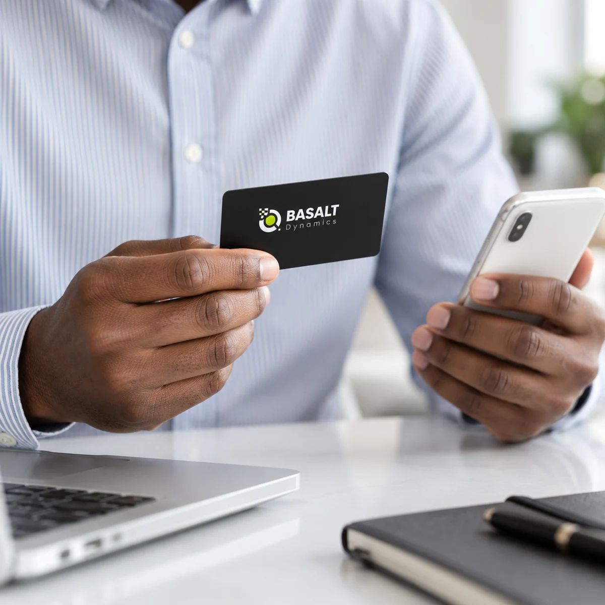 Customer holding a Basalt Dynamics payment card and a phone